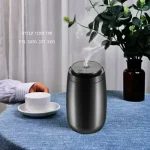 מפיץ ריח חשמלי משחרר אדים, מונח על שולחן עם צמח ומגבת, ליד כוס תה לבנה.