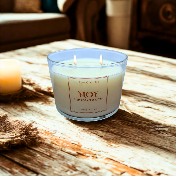 נר סויה ריחני עם שני פתילים על שולחן עץ, מוסיף אווירה נעימה לבית.