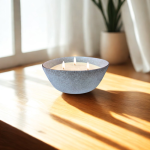 נר סויה ריחני עם שלושה פתילים מונח על שולחן עץ, מואר באור טבעי, משתלב בסביבה נינוחה.